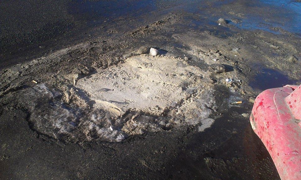 Фотофакт: Киевские коммунальщики засыпали открытый люк… песком
