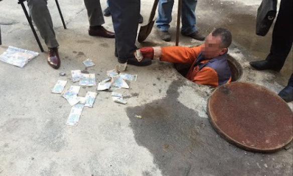 Видео дня: Cотрудник ГФС, пойманный на взятке, пытался выбросить купюры в канализацию