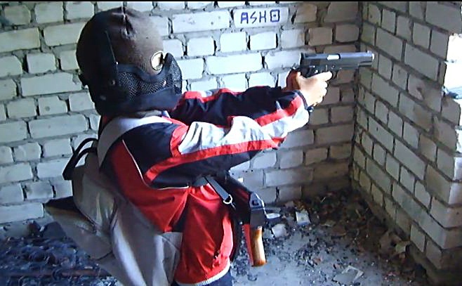 Главный регионал Николаевского горсовета Александр Демьянов учит маленького сына стрелять из пистолета